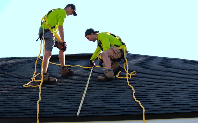 Workers on a shingle roof